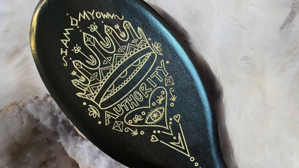 Decorative hair brush with gold engraving on a marble surface
